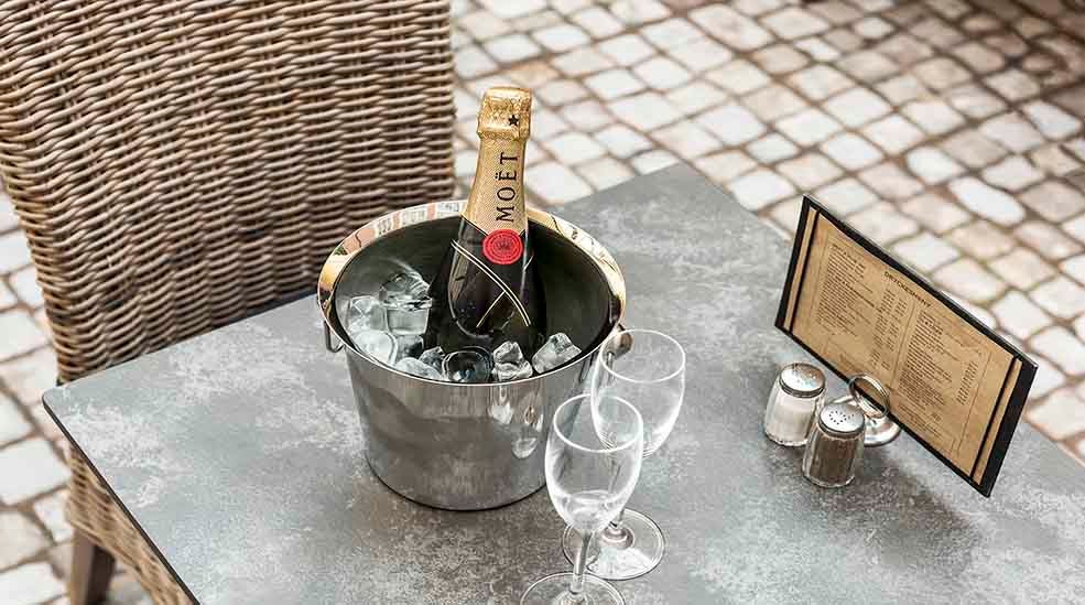  Restaurang med bord och stolar med champagne och meny på Clarion Collection Hotel Victoria Jönköping